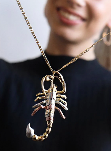 Scorpion-shaped pendant, gold color.